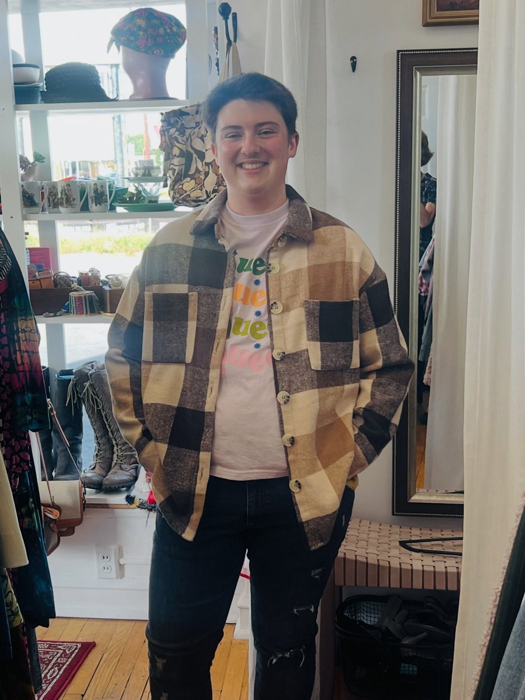 A customer wearing a brown, cream and black plaid jacket inside the shop